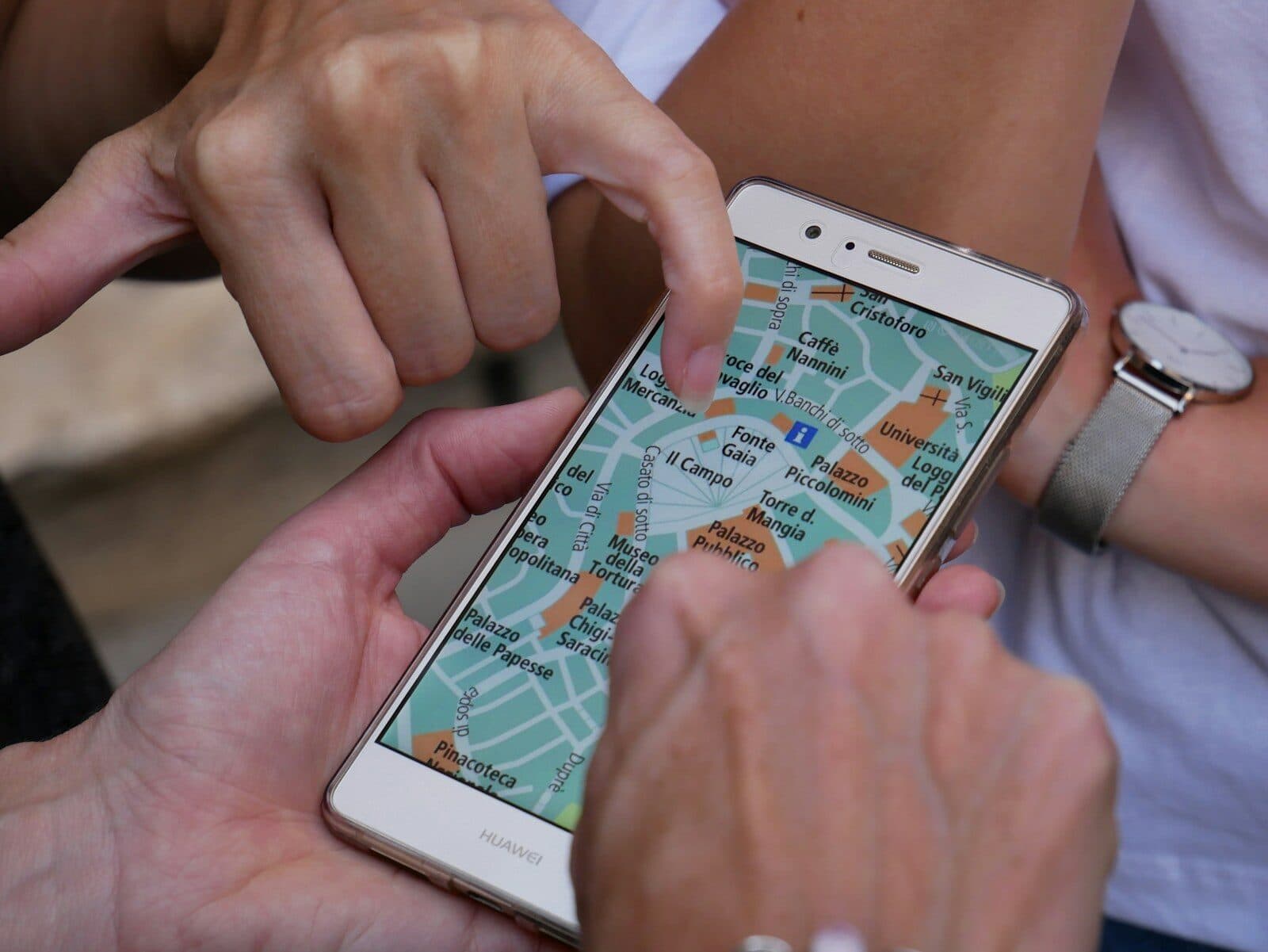 Two people pointing at a map on a smartphone