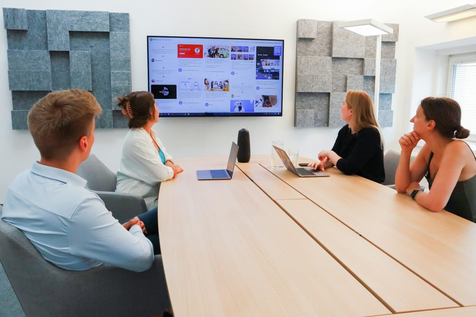 A team in a meeting room looking at a shared screen