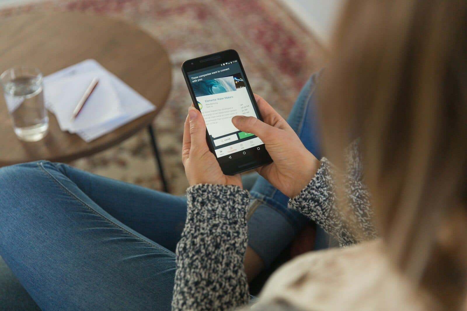 A person reading on a smartphone at home